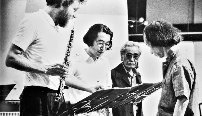 1985年8月、草津夏期国際音楽アカデミーでの一柳慧の作品個展演奏会で演奏された「雲の経」のリハーサル風景。 左より演奏者のオーボエ奏者のブルクハルト・グレッツナー、一柳 慧、ステージマネージャーの伊堂寺猛男、リハーサルを聴いていた武満徹。 撮影:林 喜代種